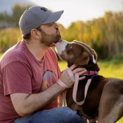 man in red shirt with brown dog